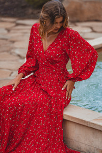 Woman in a red dress sitting by a fountain