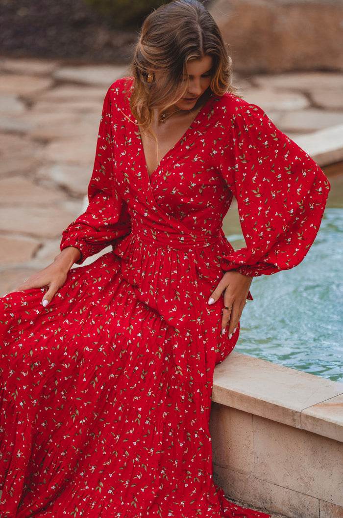 Woman in a red dress sitting by a fountain