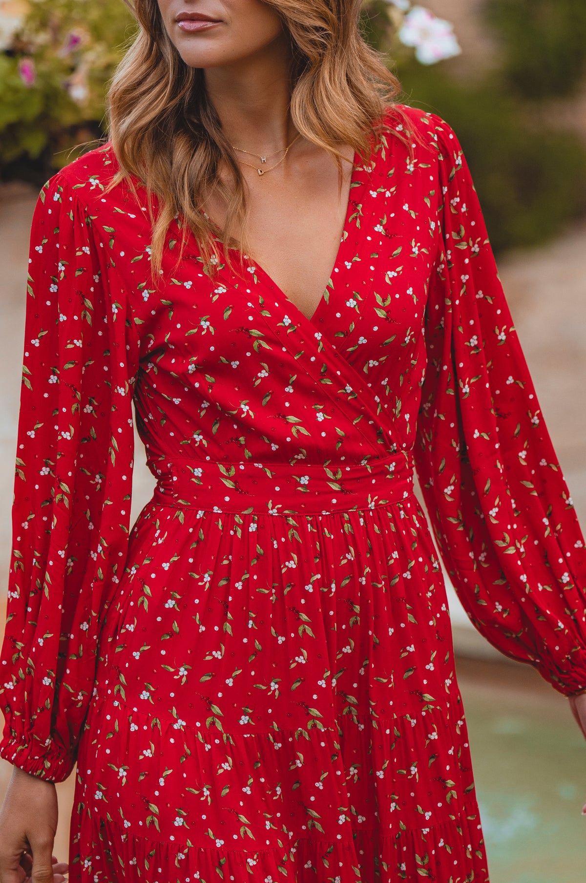 Red dress with floral pattern worn by a person, blurred background