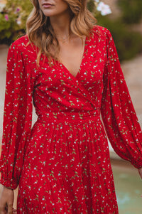 Red dress with floral pattern worn by a person, blurred background