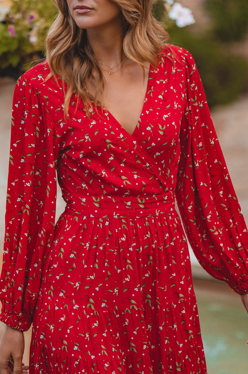Red dress with floral pattern worn by a person, blurred background