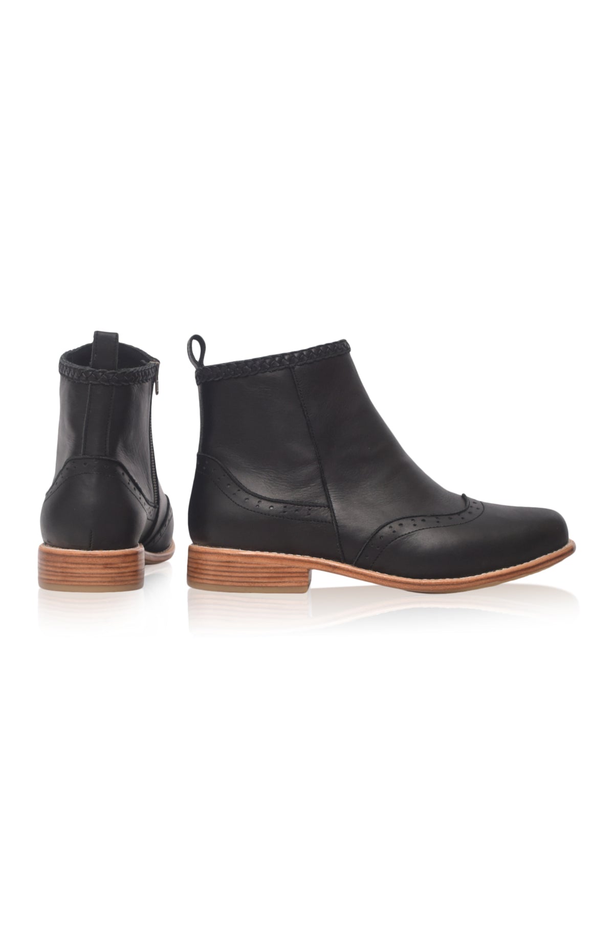 A pair of black leather ankle boots with wingtip detailing and stacked brown wooden heels, shown from the side and back on a white background.