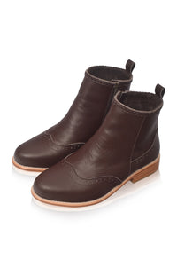 A pair of dark brown leather ankle boots with a side zipper, brogue detailing on the toe, and a low stacked heel, shown on a white background.