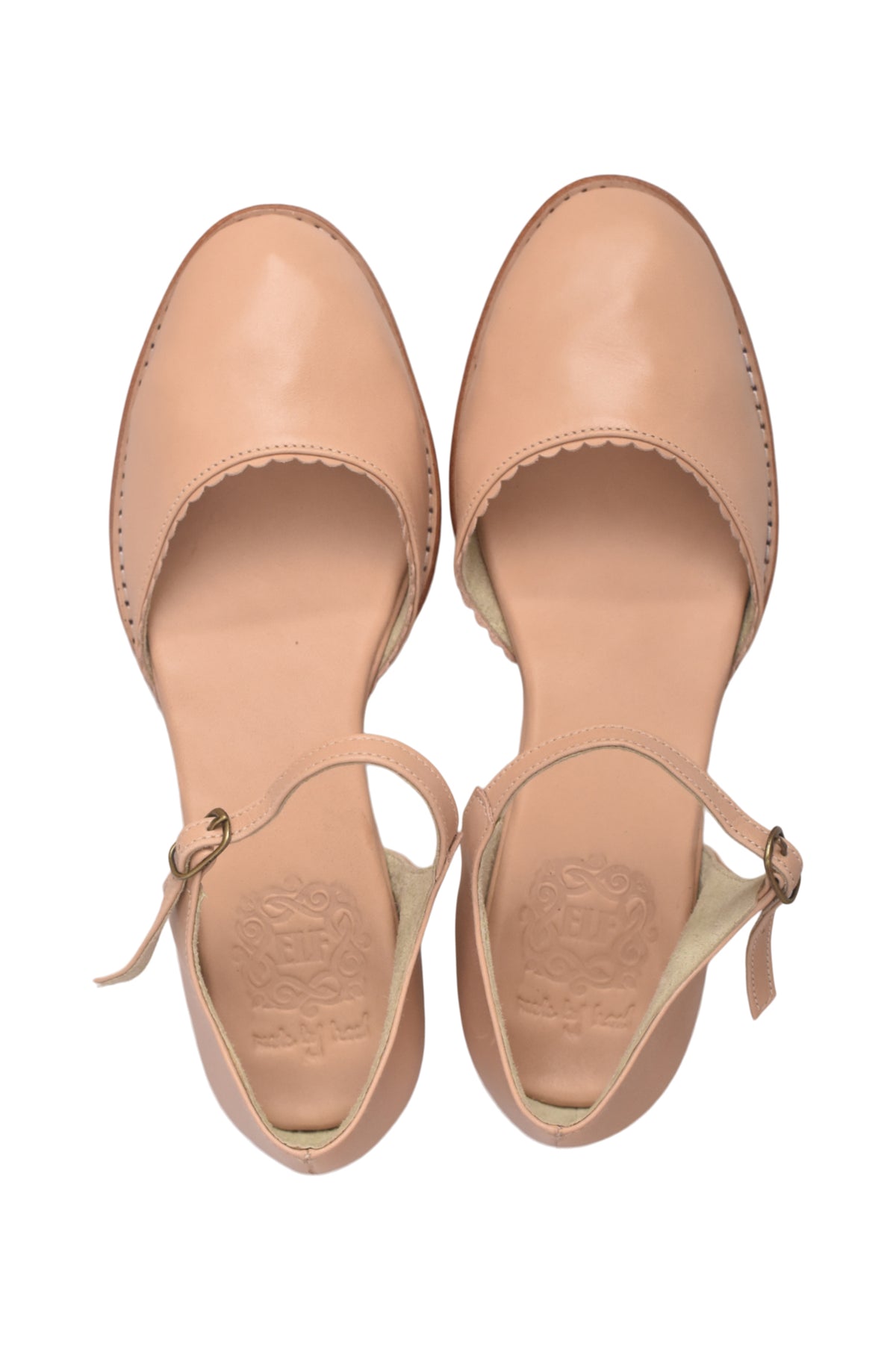 A pair of light beige leather flat sandals with scalloped edges and ankle straps, shown from a top-down view on a white background.