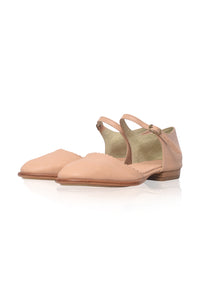 A pair of light peach flat sandals with thin ankle straps and a low block heel, displayed on a clean white background.