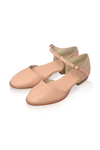 A pair of light beige leather Mary Jane flats with low block heels and ankle straps, displayed on a clean white background.
