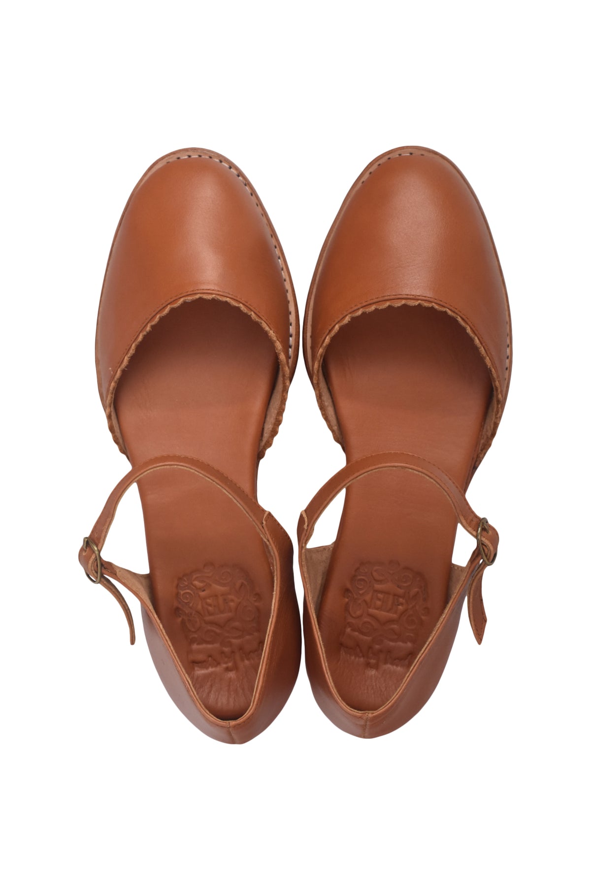 A pair of tan leather flat sandals with a single thin ankle strap and a decorative stitched edge, shown from a top-down view on a white background.