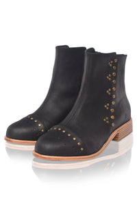 Black ankle boots with gold studs on a white background