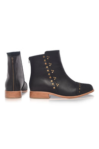 Black leather ankle boots with brown soles on a white background