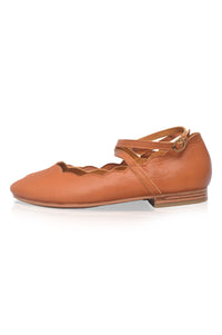 Tan leather ballet flat shoe with a strap on a white background