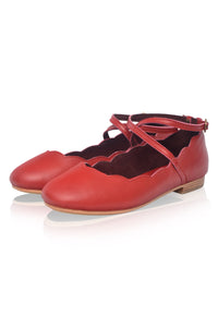 Red ballerina shoes with a strap on a white background