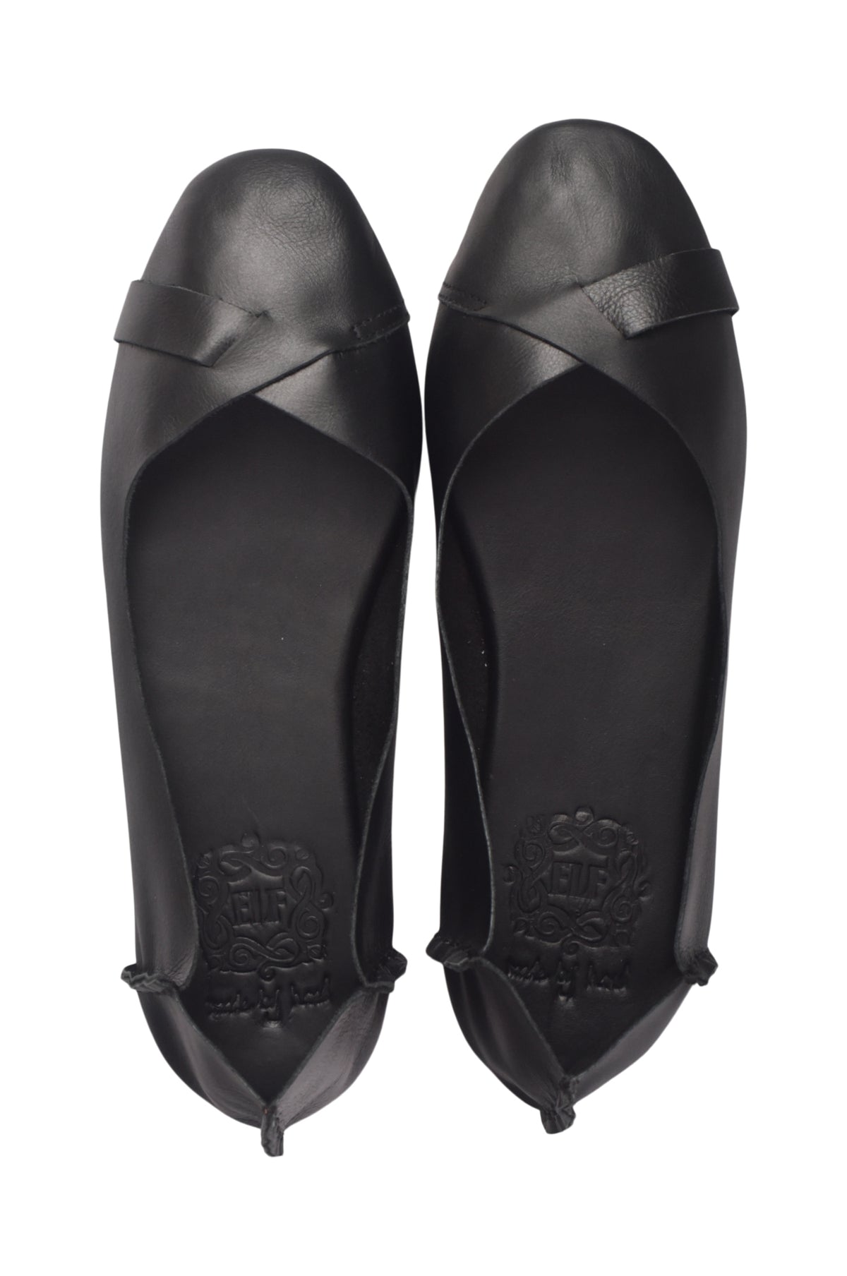 A pair of black leather ballet flats shown from a top-down view, featuring a criss-cross strap design across the toes and a low wedge heel, set against a plain white background.