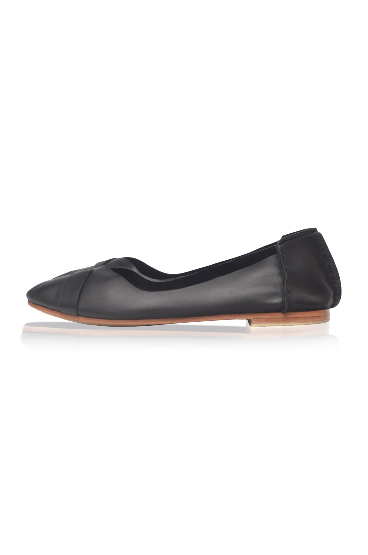 A single black leather ballet flat shoe with a pointed toe and a light brown wooden-look sole, shown in profile against a white background.