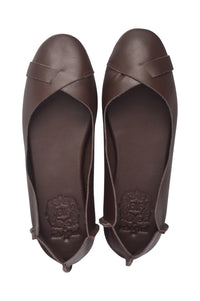 A pair of dark brown leather ballet flats shown from a top-down view, featuring a crossover strap design on the toe and a debossed brand logo on the insole.