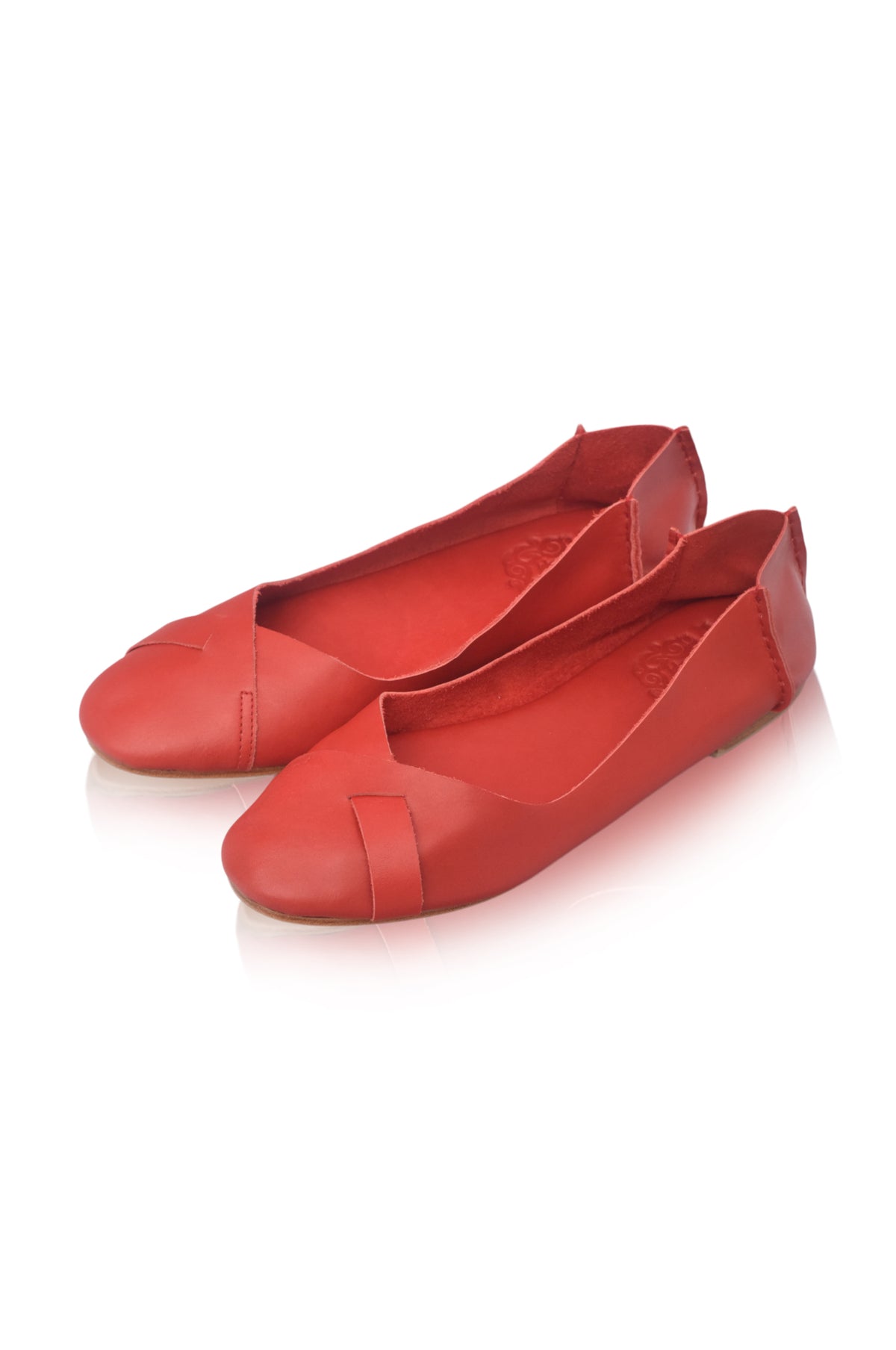 A pair of bright red leather ballet flats with a pointed toe and a decorative strap detail on the vamp, displayed on a clean white background.