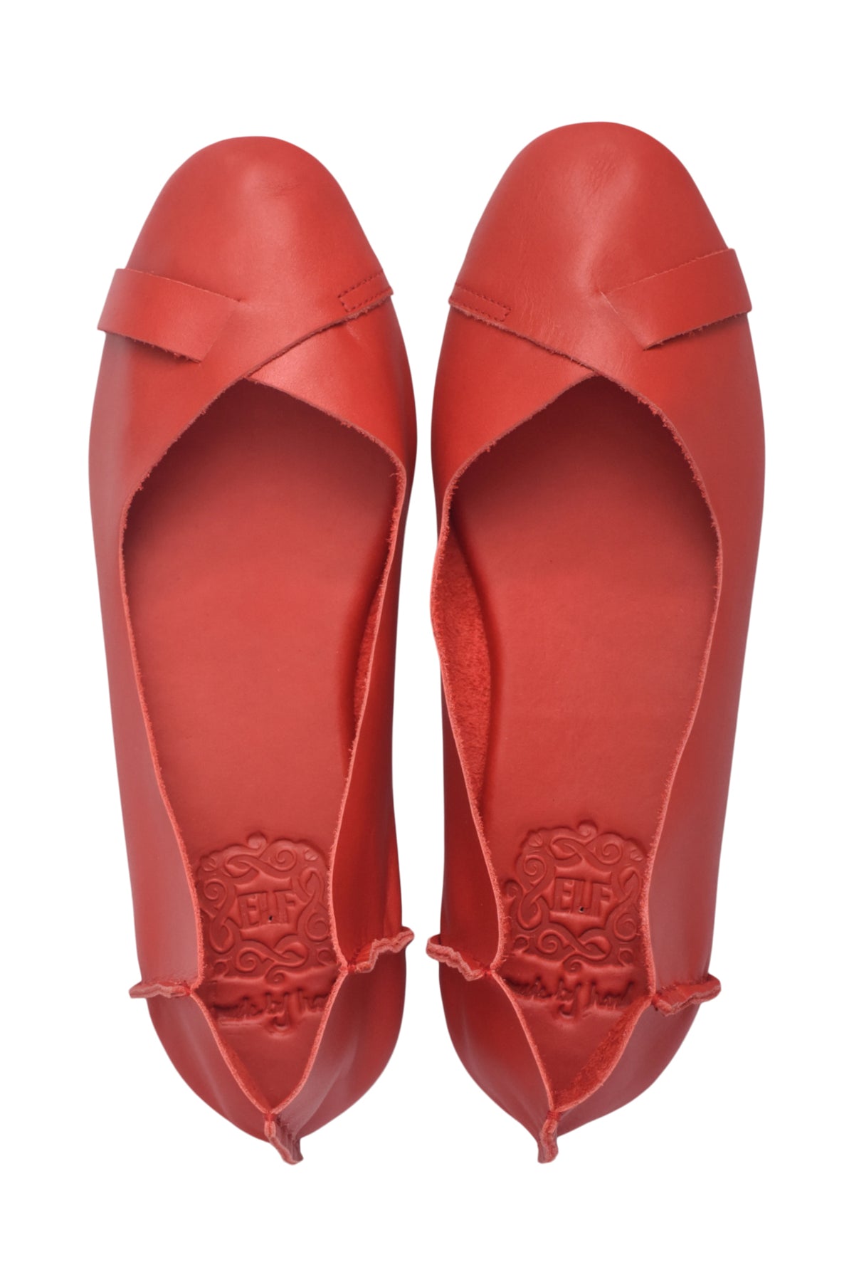 A pair of red leather ballet flats with a crossover strap across the instep, shown from a top-down view on a white background.