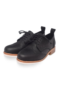 Black leather shoes with brown soles on a white background