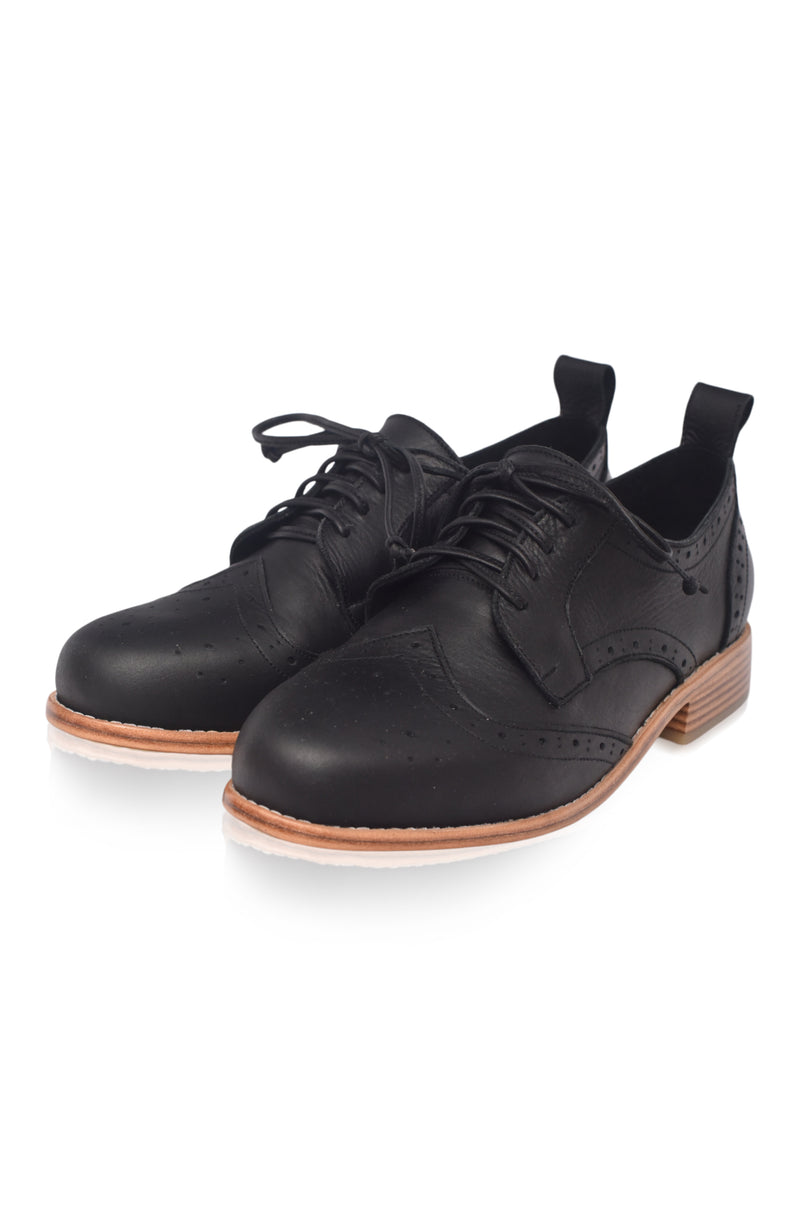 Black leather shoes with brown soles on a white background