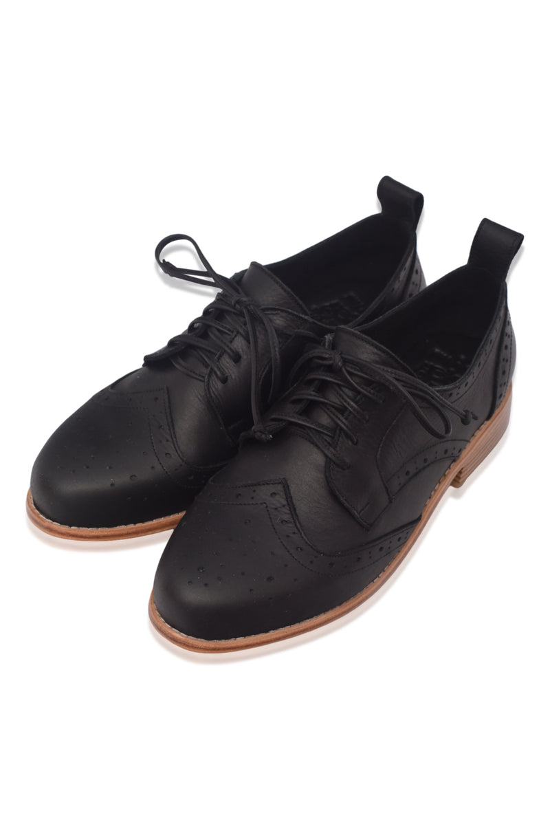 Pair of black leather shoes with brown soles on a white background