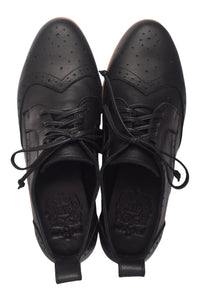 Pair of black leather shoes with laces on a white background