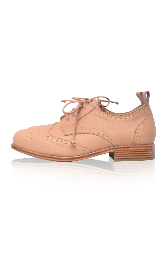 Beige brogue shoe on a white background
