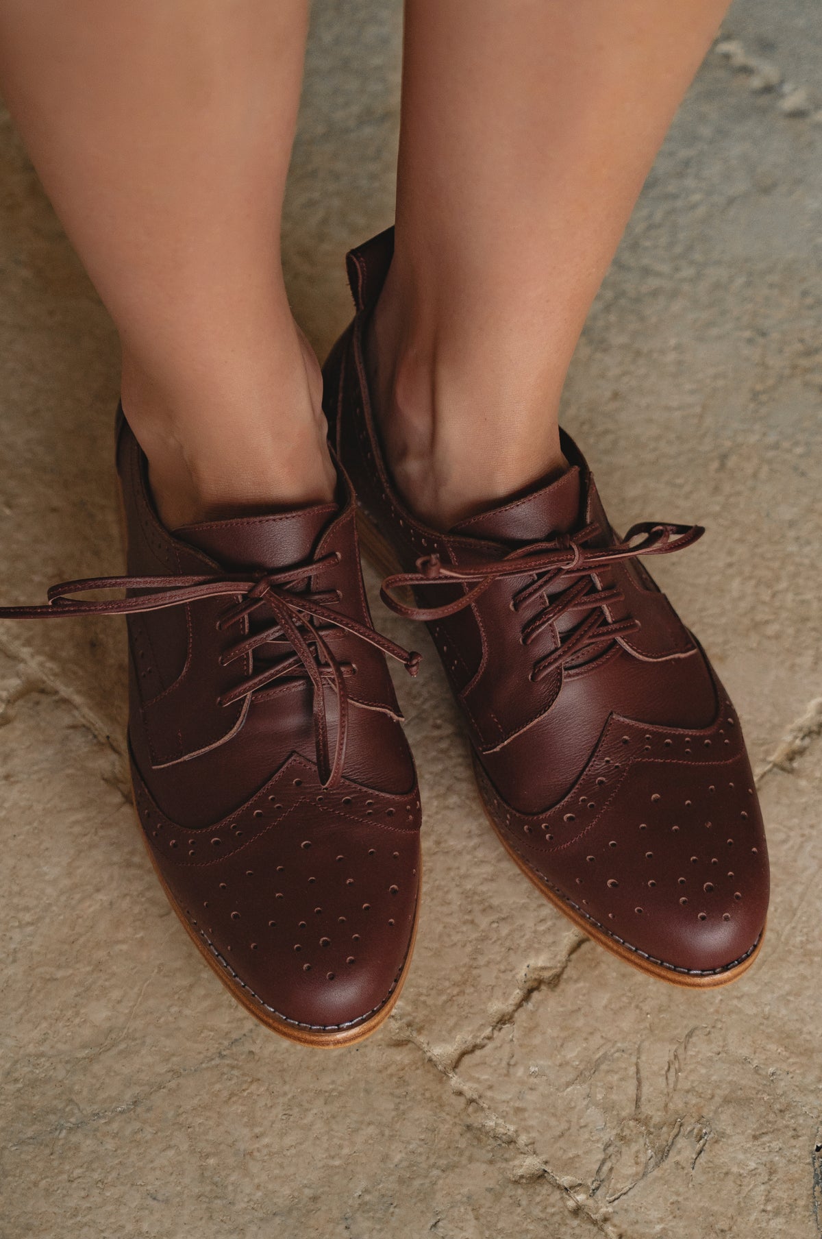 Brown leather shoes on a stone surface
