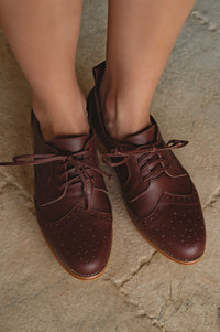 Brown leather shoes on a stone surface