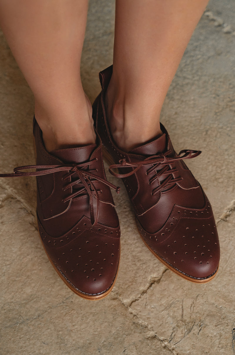 Brown leather shoes on a stone surface