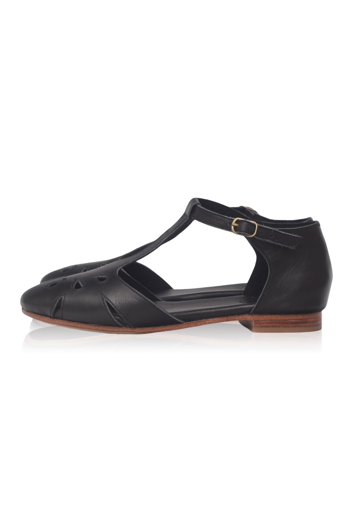 Black flat shoe with a strap on a white background