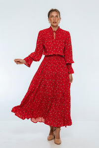 Woman wearing a red floral dress on a white background