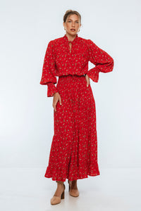 Woman wearing a red floral dress on a white background