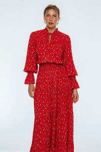 Woman wearing a red dress with a subtle pattern on a white background
