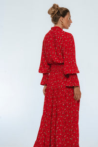 Woman wearing a red floral dress against a white background