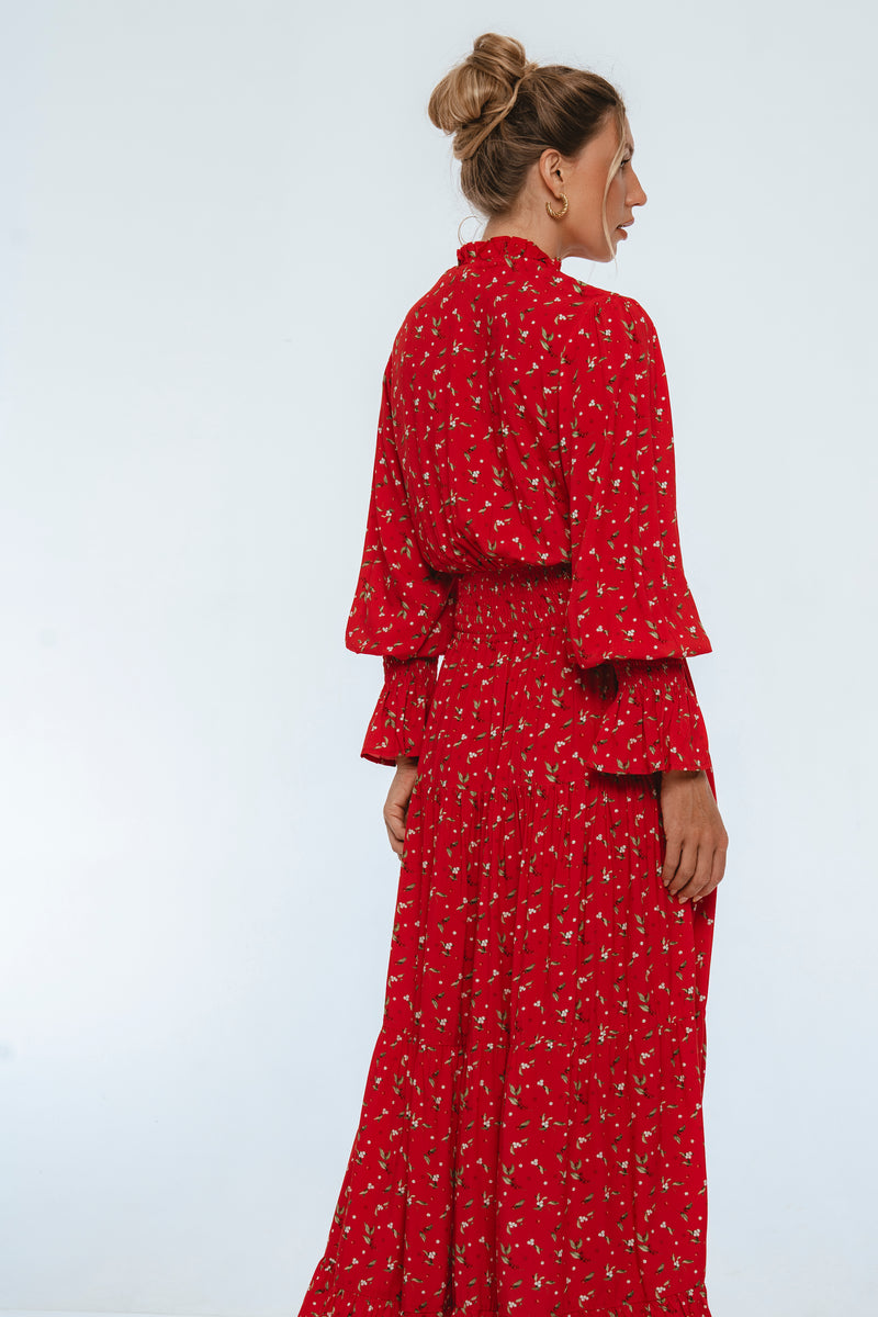 Woman wearing a red floral dress against a white background