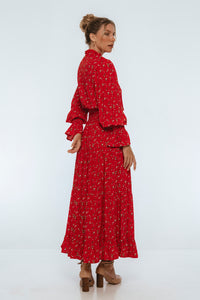 Woman wearing a red floral dress on a white background