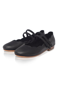 Pair of black leather shoes with leather soles on a white background