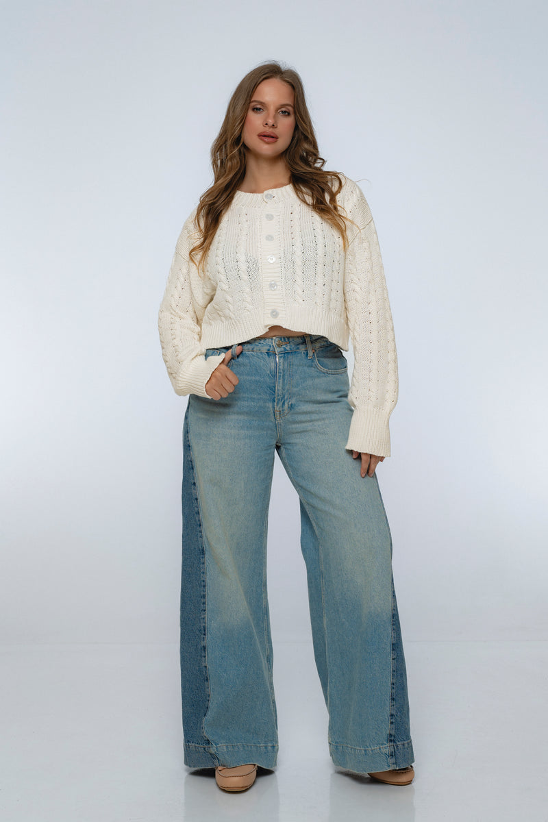 Woman wearing a white sweater and blue jeans on a white background