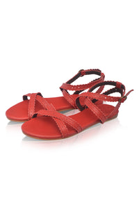 Red leather flat sandals with crisscrossing straps and an adjustable ankle strap, displayed on a clean white background with a soft reflection.