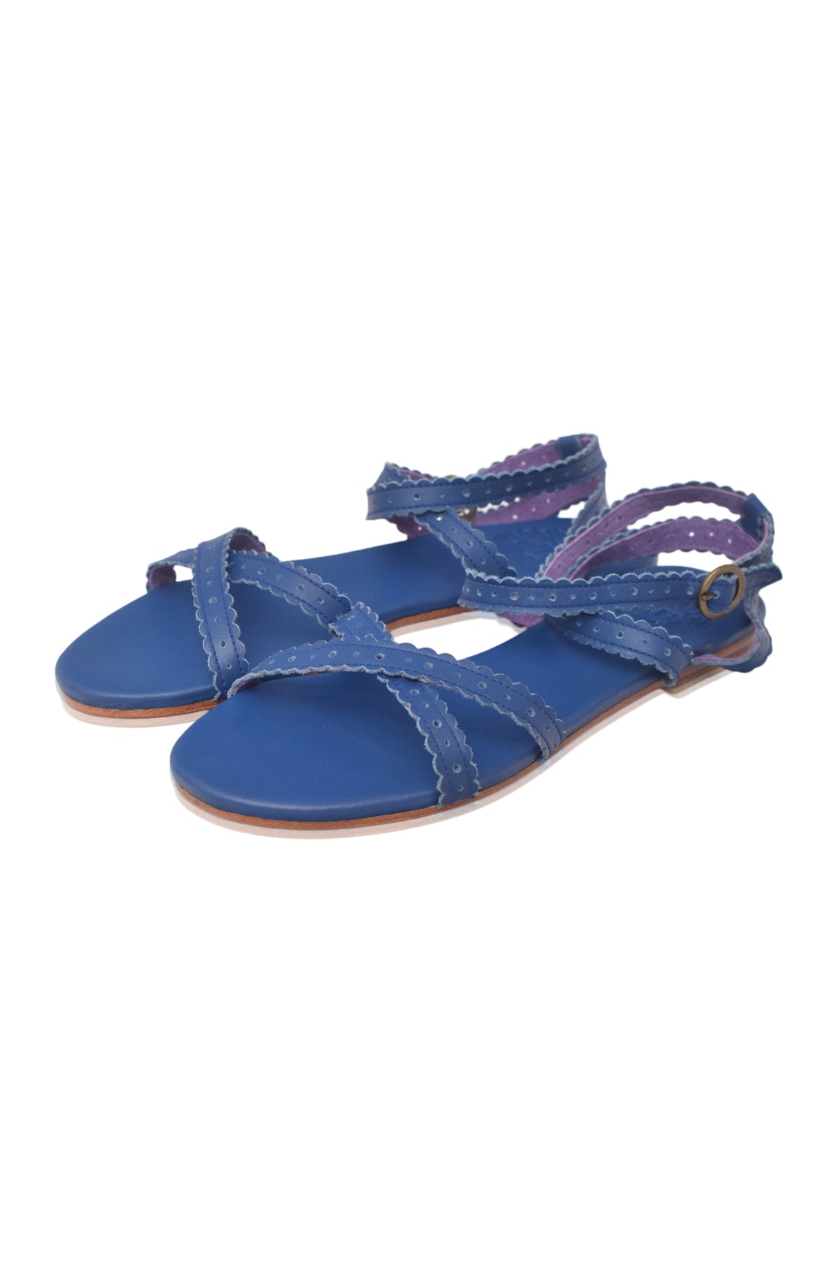 A pair of blue flat sandals with braided crisscross straps and adjustable ankle straps, shown on a plain white background.