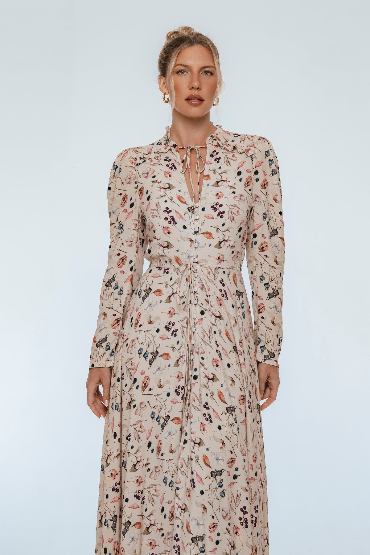 Woman wearing a floral dress against a plain background