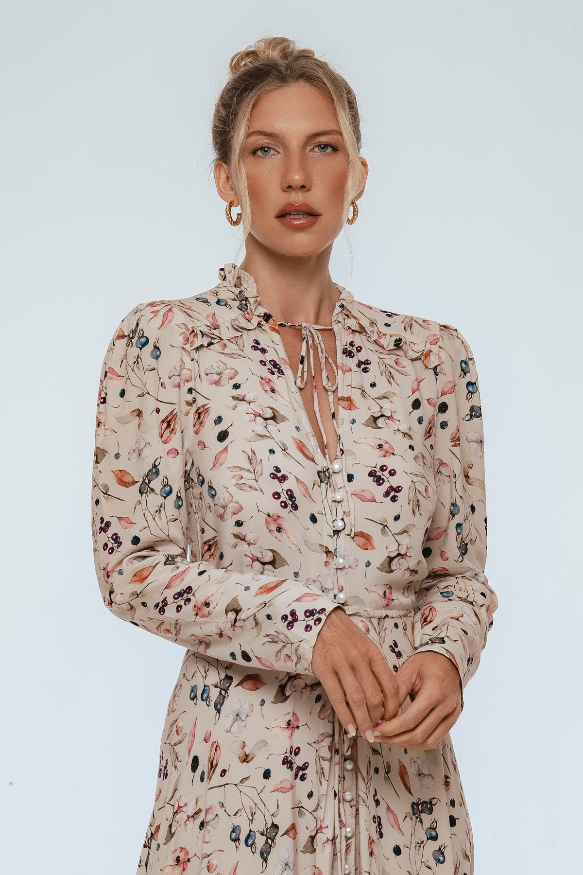 Woman wearing a floral dress against a plain background