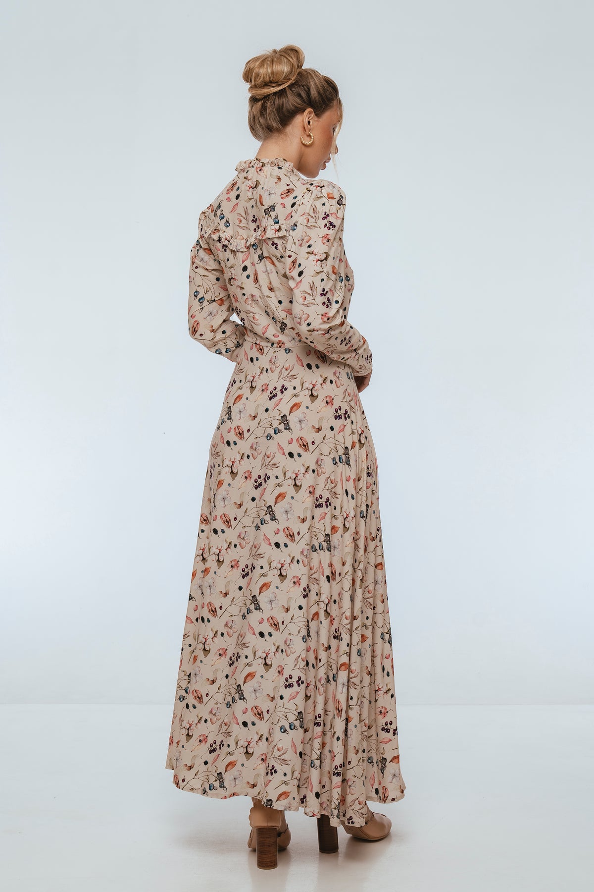 Woman wearing a long floral dress on a white background