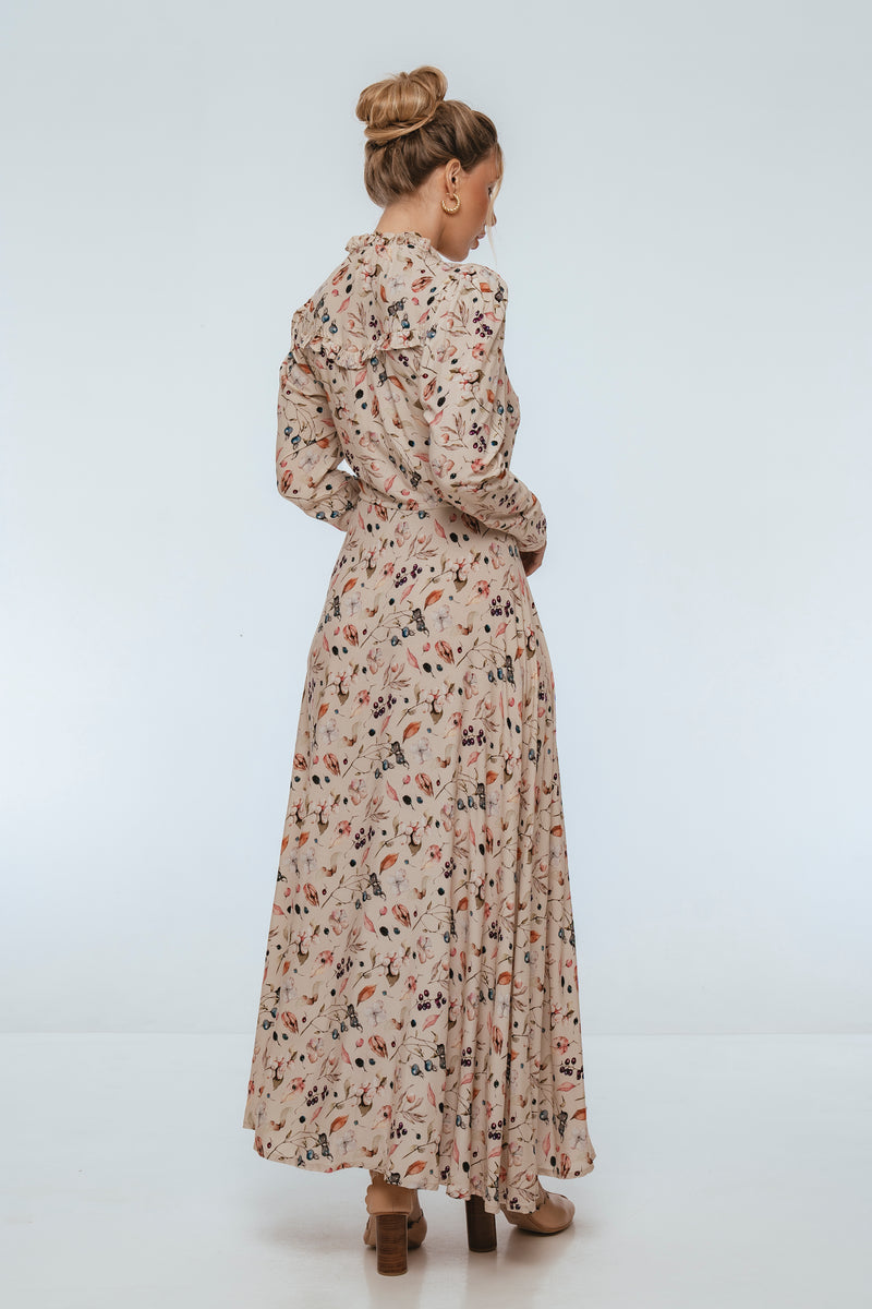 Woman wearing a long floral dress on a white background