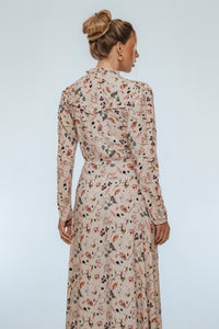 Woman wearing a floral dress against a plain background