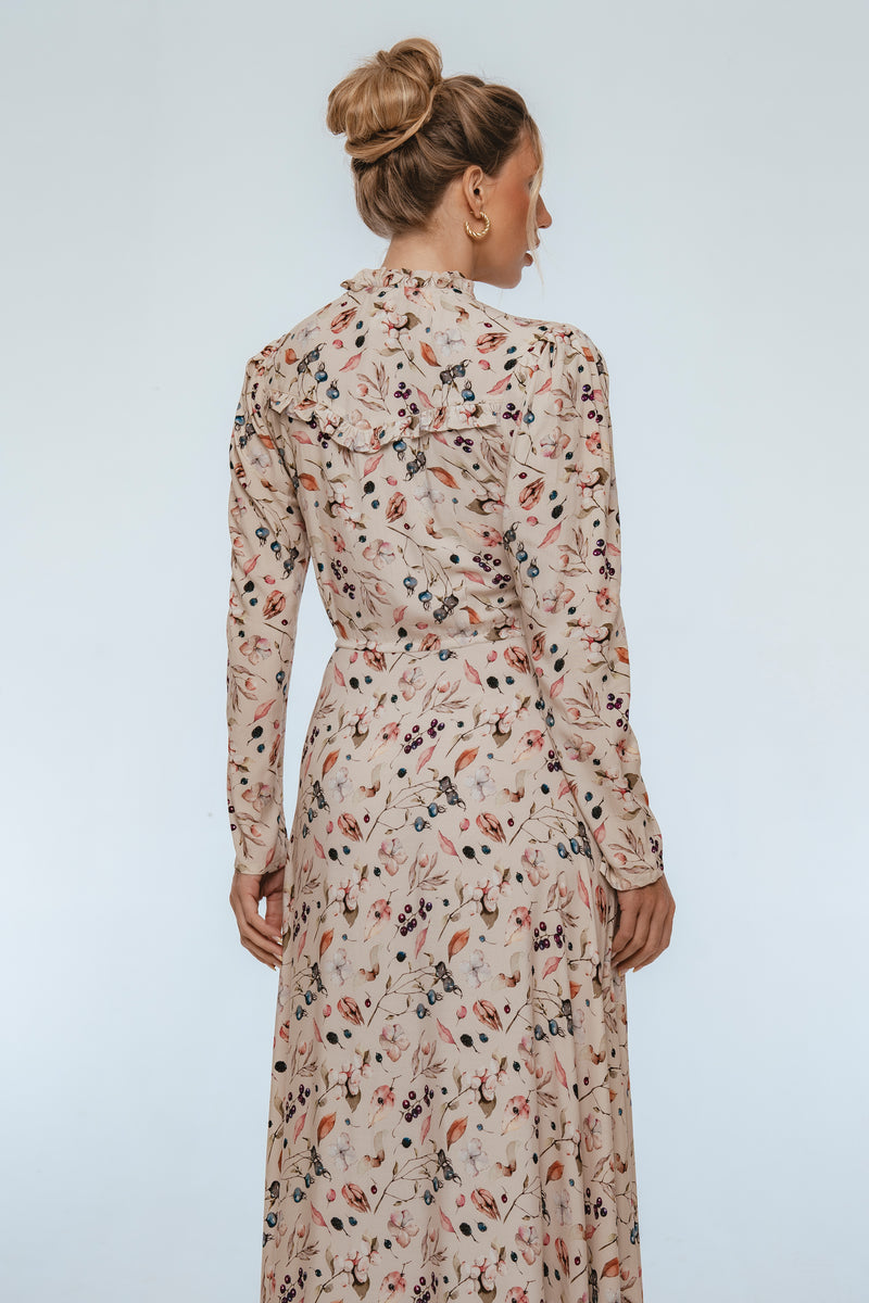 Woman wearing a floral dress against a plain background