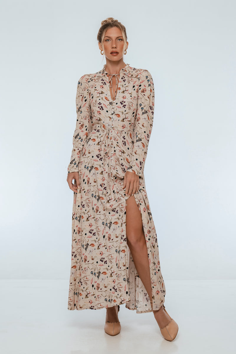 Woman wearing a floral dress with a slit on a white background