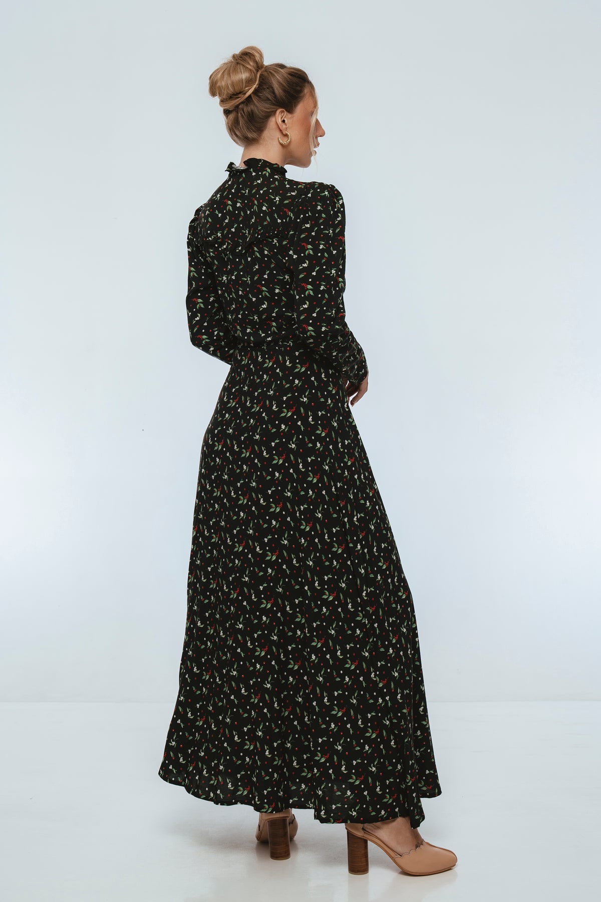 Woman wearing a black floral dress on a white background