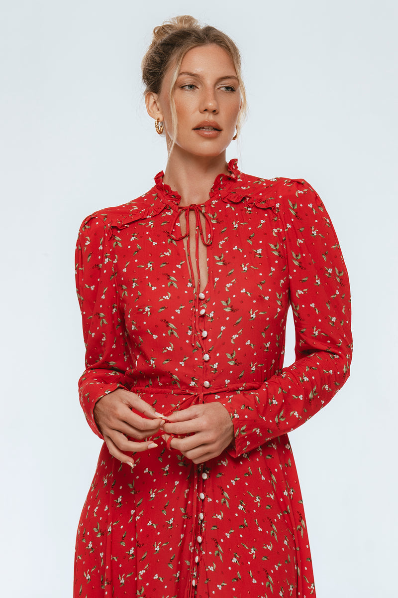 Woman wearing a red floral dress on a white background