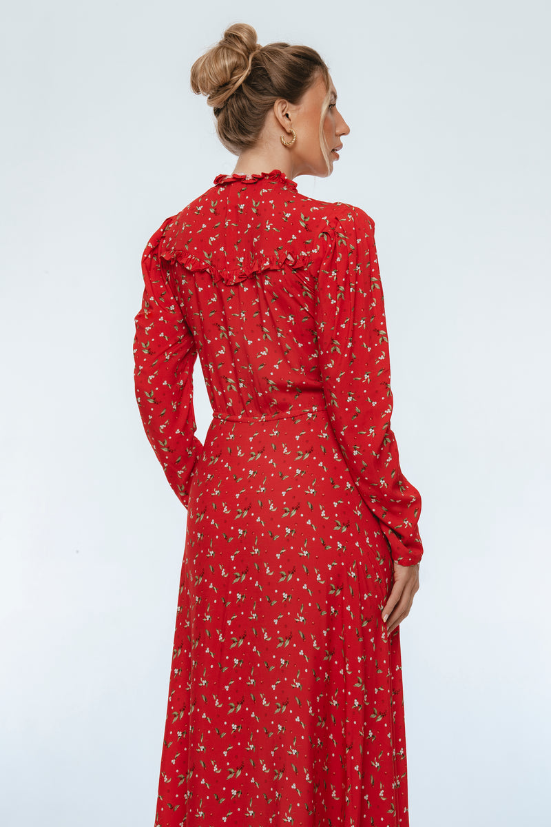 Woman wearing a red floral dress against a white background