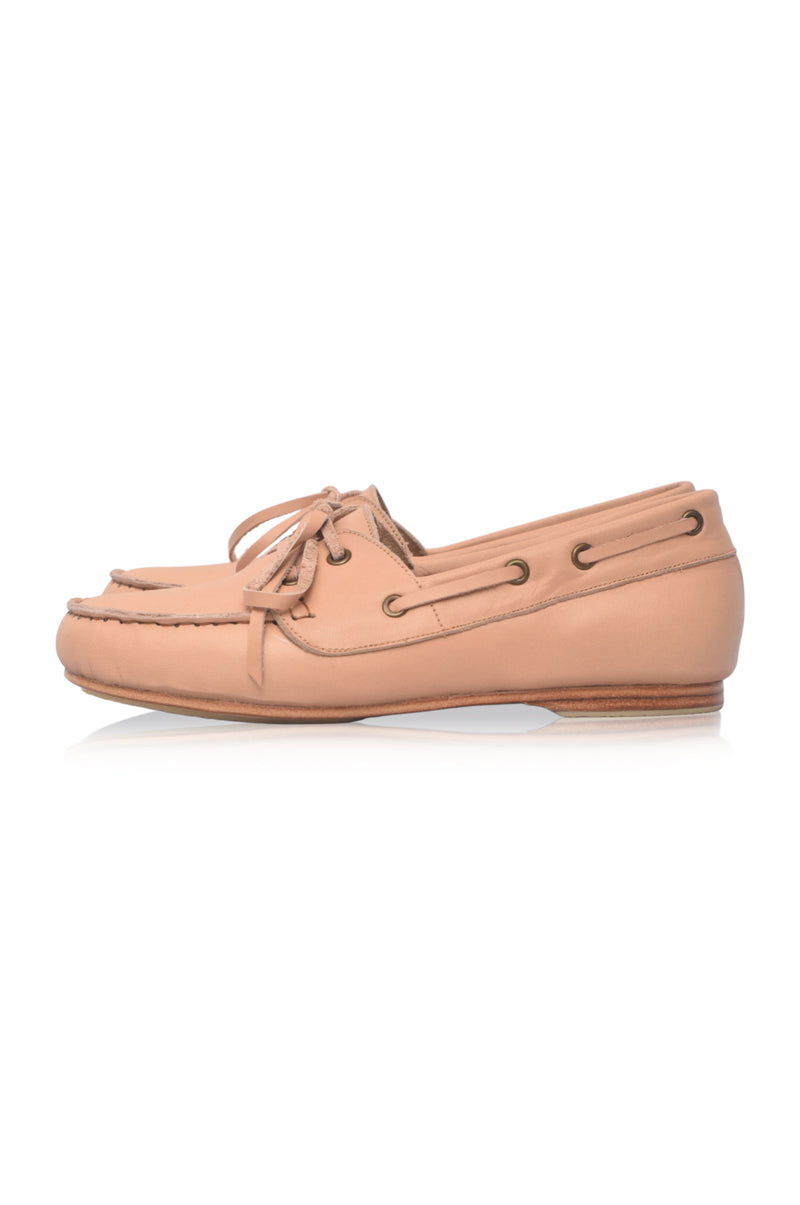 Pair of tan boat shoes on a white background